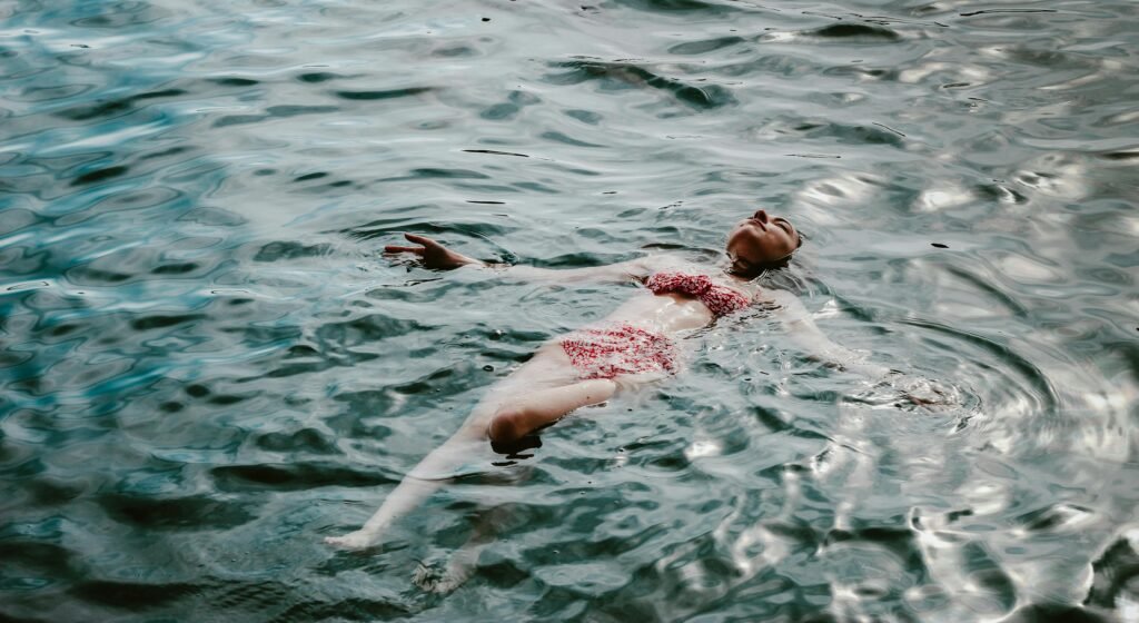 A woman relaxes in a bikini, floating in a serene lake in Muğla, Türkiye.