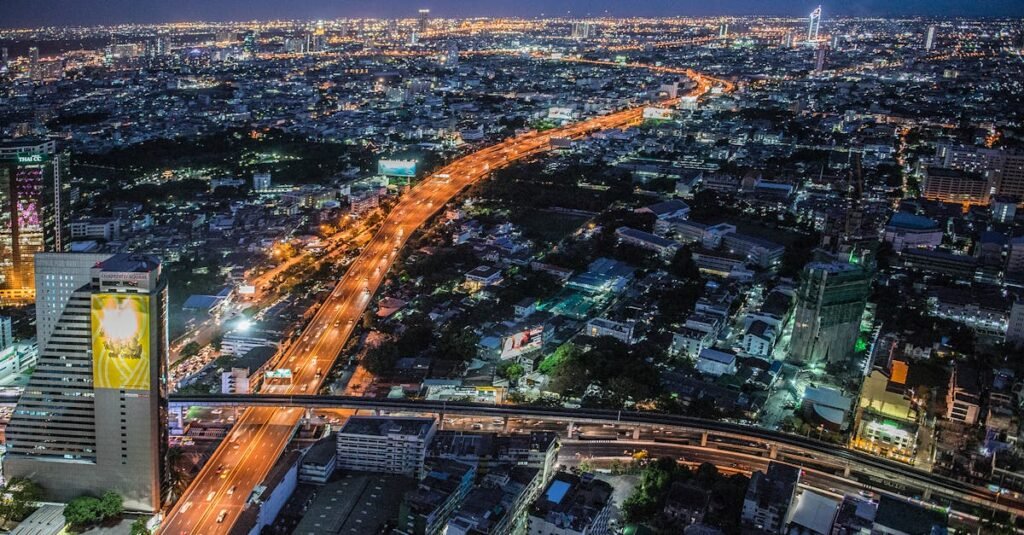 A stunning aerial view of Bangkok at night, showcasing the illuminated skyline and bustling urban life.