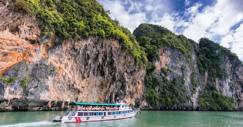 A boat cruise offers breathtaking views of lush cliffs under a bright blue sky.